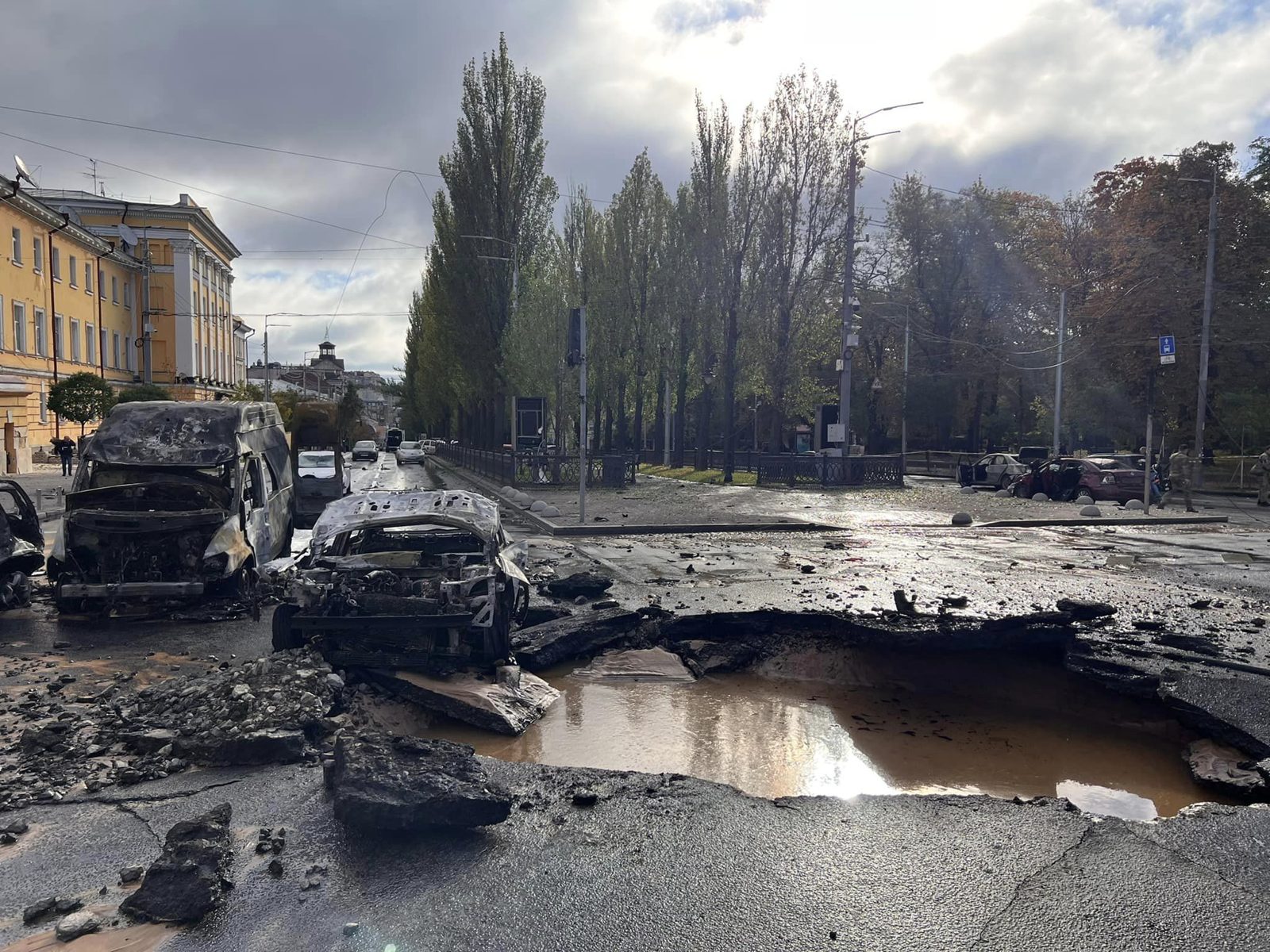 Burned-out vehicles and debris on a Kyiv street after Russian shelling on 10 October 2022.